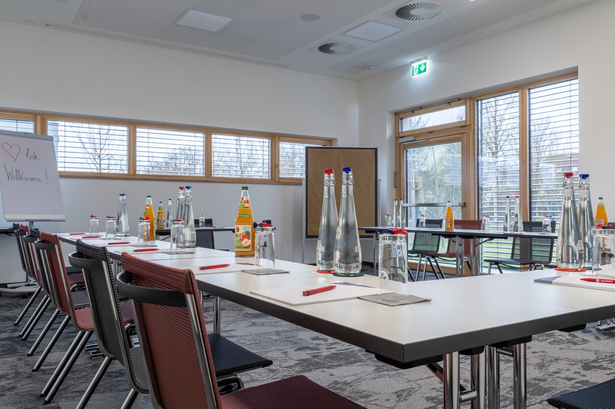 Tagungsraum mit Tischen und Stühlen im Hotel Includio Regensburg