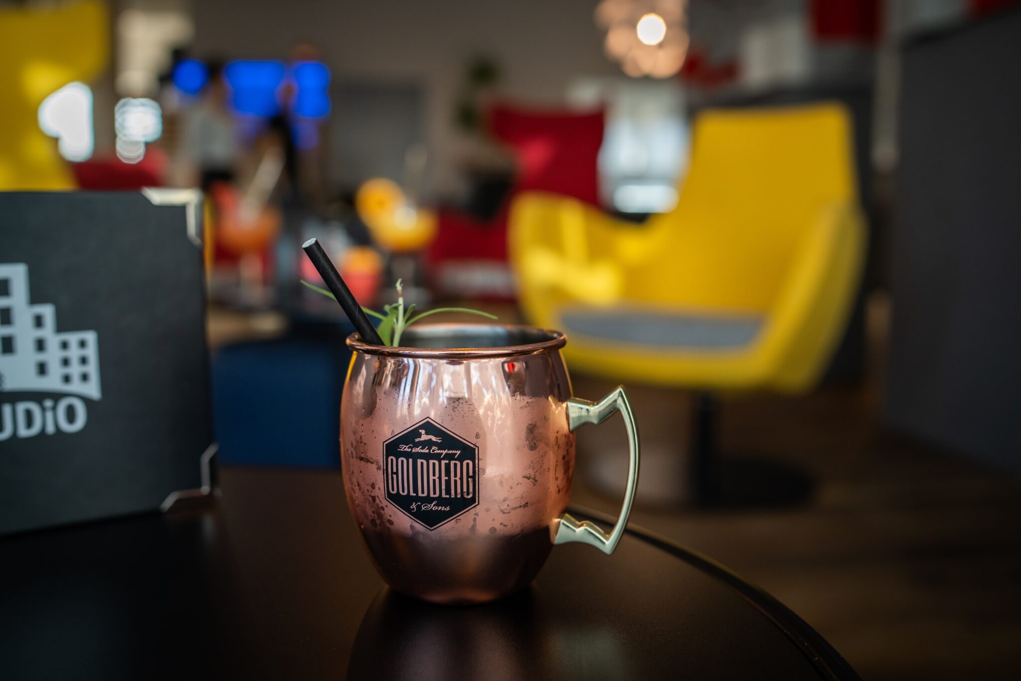 Kupferbecher mit dem Schriftzug 'Goldberg' und einem Strohhalm, gefüllt mit einem Cocktail.